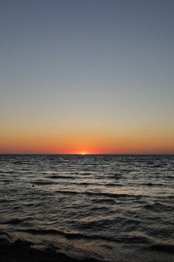 Altın gün batımı ya da derin karanlık okyanusta gün doğumu. Gün batımının havadan görünüşü ve deniz manzarası. Sarı ve turuncu renkli gökyüzü. Romantik gökyüzü bahar mevsiminde