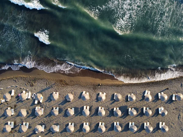 从上方俯瞰 令人叹为观止的空旷的海滩 白色的海滩遮阳伞 碧绿清澈的水面 夏日波涛汹涌 — 图库照片
