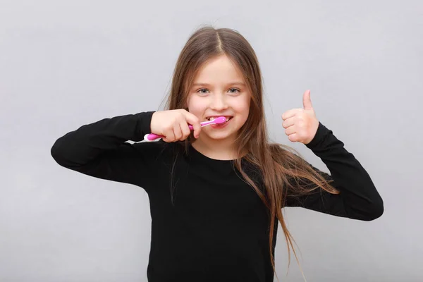 Szczęśliwe Dziecko Dziewczynka Myje Zęby Szczoteczką Zębów Pokazuje Kciuk Górę — Zdjęcie stockowe