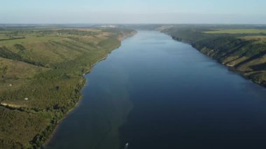 Ukrayna 'daki Podolski Tovtry Ulusal Parkı' nın bir parçası olan yaz güneşli günlerinde geniş Dinyester nehri ve Dakota bölgesindeki uzak yeşil tepelerin havadan görüntüsü. 4k