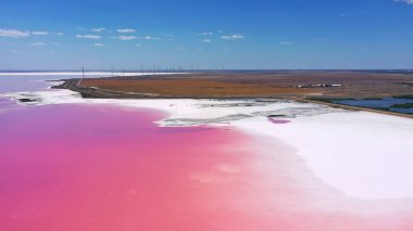 Pembe Ada 'daki adanın kıyılarındaki beyaz tuzun ve mavi gökyüzünün havadan görünüşü. Lemuria Gölü, Ukrayna. Göl, tuzlar ve sudaki kabuklu deniz ürünleri yüzünden doğal olarak pembeleşir..