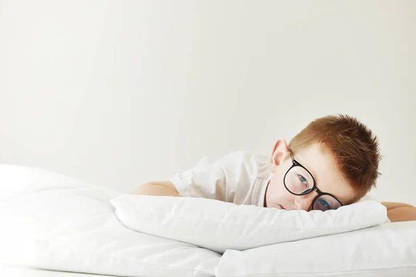 Uroczy Chłopiec Okularach Leży Łóżku Poranne Sny Białym Łóżku — Zdjęcie stockowe