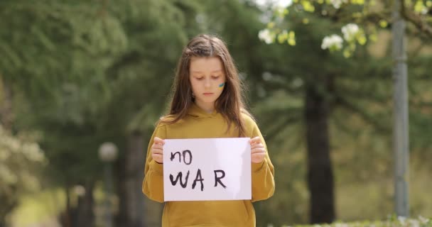 Ukraynalı zavallı kız evsizlerin savaş savaşını protesto etmesi üzerine açık havada savaş yok yazılı masaj metniyle afişi kaldırdı. Kriz, barış, saldırganlığı durdurun, Rus savaşına karşı çocuk — Stok video