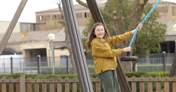 Kid girl está se divertindo enquanto joga no playground ao ar livre. Ensino externo. — Vídeo de Stock