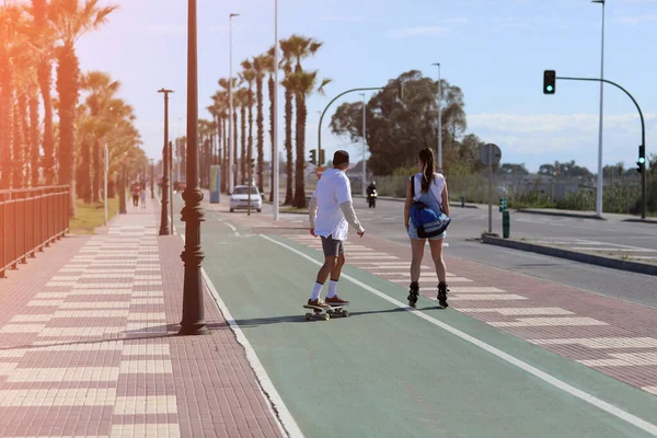 Holidays Vacations Woman Roller Skates Man Skateboard Having Fun Outdoors — Foto de Stock