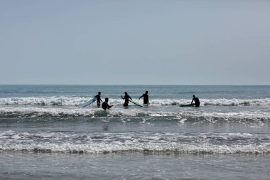 İspanya-Castellon, 16 Nisan 2022: Akdeniz 'de sörf tahtasında yüzmeyi öğrenen bir grup insan. 