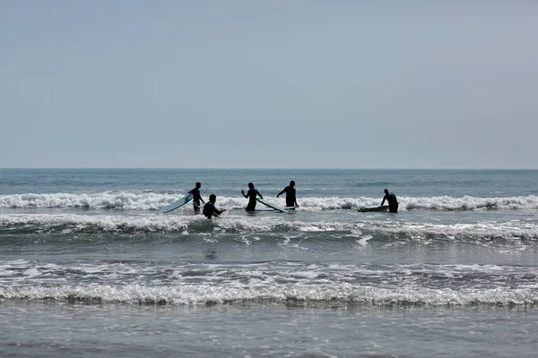 İspanya-Castellon, 16 Nisan 2022: Akdeniz 'de sörf tahtasında yüzmeyi öğrenen bir grup insan. 