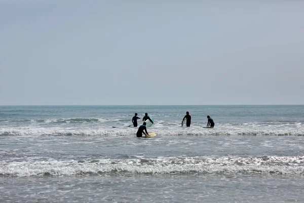 İspanya-Castellon, 16 Nisan 2022: Akdeniz 'de sörf tahtasında yüzmeyi öğrenen bir grup insan. 