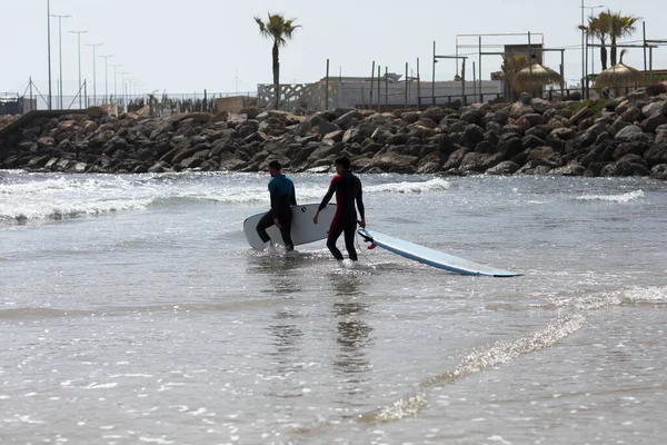 İspanya-Castellon, 16 Nisan 2022: Akdeniz 'de sörf tahtasında yüzmeyi öğrenen bir grup insan. 