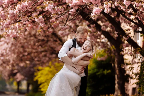 Hermosos Alegres Animados Recién Casados Novio Novia Abrazan Cerca Floreciente —  Fotos de Stock