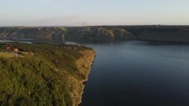 Geniş Dnister nehri ve Ukrayna 'daki Podilski Tovtry Ulusal Parkı' nın bir parçası olan Bakota bölgesindeki uzak kayalık tepelerin havadan görüntüsü. 4 bin. Yüksek kalite 4k görüntü.