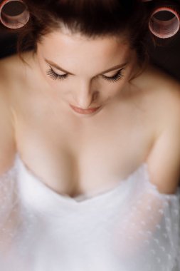 Güzellik konsepti Pembe bukleli parlak makyajlı, gösterişli, genç bir esmer kadının portresi. Stüdyo Çekimi, Kırpılmış. Yüz bakımı. Kozmetoloji, cilt bakımı ve kaplıca.