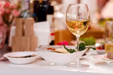 Lokantada şarap içen genç kızın resmini çek. Restoranda bir bardak şarap. Seçici odak