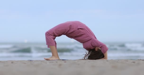 Yoga Minderinde Bir Kız Çocuğu Deniz Kenarındaki Kumda Köprü Kaçırma — Stok video