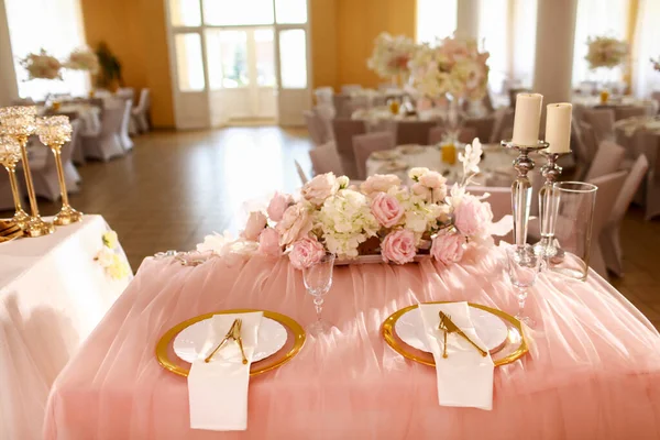 ピンクのテーブルクロスとテーブルの装飾 レストランでキャンドルや白ピンクの花とクリスタルキャンドルスティック スタイリッシュな結婚式の日 金のプレートとフォークとナイフでテーブルを — ストック写真