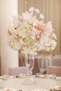 Şenlikli düğün dekorasyonu. Düğün günü yemek masasında cam vazoda duran güzel, beyaz ve pembe çiçekler. Yüksek kalite fotoğraf.