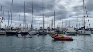 Castellon, İspanya - 1 Mayıs 2022: Bir grup çocuk yaz kampında kanoda yüzüyorlar. Kasabanın limanı.