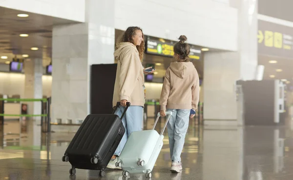 飛行機の前に空港で家族 バックビュー国際線ターミナルの出発ゲートに行くスーツケースを持つ母と娘 旅行や子供と一緒に飛ぶ 子供の搭乗機とお母さん — ストック写真