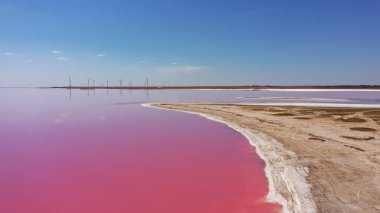 Pembe Ada 'daki adanın kıyılarındaki beyaz tuzun ve mavi gökyüzünün havadan görünüşü. Lemuria Gölü, Ukrayna. Göl, tuzlar ve sudaki kabuklu deniz ürünleri yüzünden doğal olarak pembeleşir..