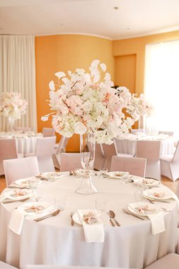 Şenlikli düğün dekorasyonu. Düğün günü yemek masasında cam vazoda duran güzel, beyaz ve pembe çiçekler. Yüksek kalite fotoğraf.