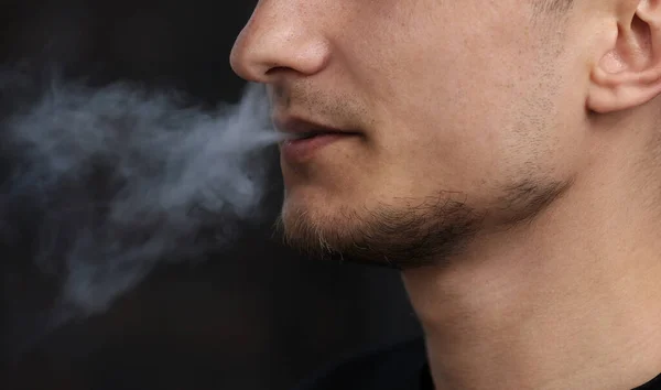 電子タバコを吸った男の近くに 人間は自然な背景で電子タバコを吸う ヒップスターは電子タバコを吸い煙の流れを呼吸し屋外のコピースペースを蒸発させ — ストック写真