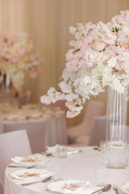 Şenlikli düğün dekorasyonu. Düğün günü yemek masasında cam vazoda duran güzel, beyaz ve pembe çiçekler. Yüksek kalite fotoğraf.