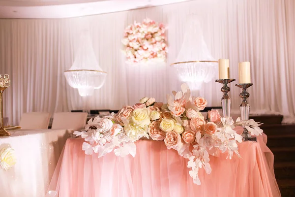 クリスタルシャンデリア 黄金の燭台 ろうそく 白いピンクの花とピンクの布で祭りの結婚式のテーブルの装飾 おしゃれな結婚式の日 — ストック写真