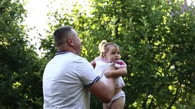 Mutlu baba doğaya bebek atar, kız gökyüzünde uçar. Baba ve kızı açık havada birlikteler. Küçük kızıyla birlikte parkta yürüyen genç bir baba. Bahçede ya da ormanda aile tatili