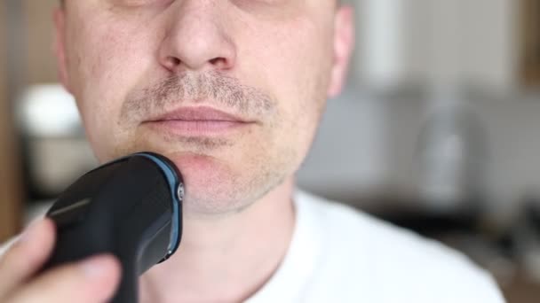 在家里的浴室里 穿着白色T恤的白人男子正在用电动剃须刀刮胡子 — 图库视频影像