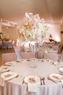 Şenlikli düğün dekorasyonu. Düğün günü yemek masasında cam vazoda duran güzel, beyaz ve pembe çiçekler. Yüksek kalite fotoğraf.