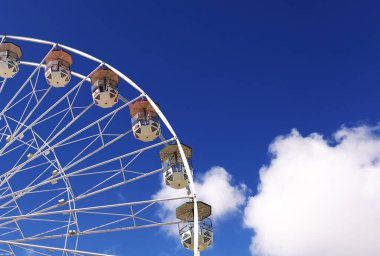Mavi gökyüzü arka planındaki lunaparkın dönme dolabı. Mavi gökyüzü arka planındaki lunaparkın renkli dönme dolabı.