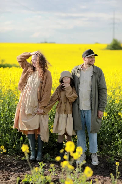 Genç baba, anne ve kız sarı tecavüz tarlalarında oynuyorlar. Aile doğada eğleniyor. Arkadaş canlısı aile kavramı ve yaz tatili. Babalar Günü, Anneler Günü ve Bebek Günü.