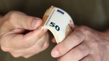 Adam Para Sayıyor. 50 Euro 'luk banknotları saymak için erkek ellerine yaklaş. Avro döviz kuru. Nakit para hesaplaması. Maaş kavramı