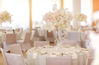 Şenlikli düğün dekorasyonu. Düğün günü yemek masasında cam vazoda duran güzel, beyaz ve pembe çiçekler. Yüksek kalite fotoğraf.