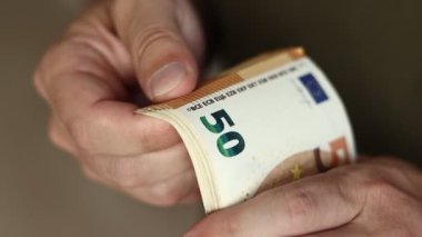 Adam Para Sayıyor. 50 Euro 'luk banknotları saymak için erkek ellerine yaklaş. Avro döviz kuru. Nakit para hesaplaması. Maaş kavramı.