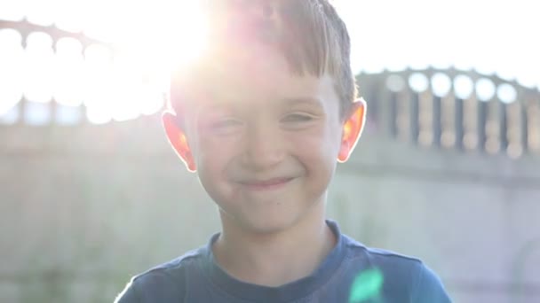Portrait Cute Smiling Little Boy Looking Camera Outdoors Sun Rays — ストック動画