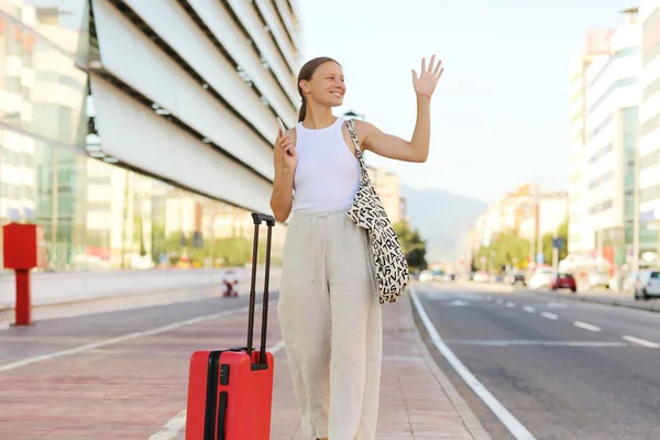 Young Beautiful Woman Red Suitcase Smartphone Raising Hand Catch Taxi — Stockfoto