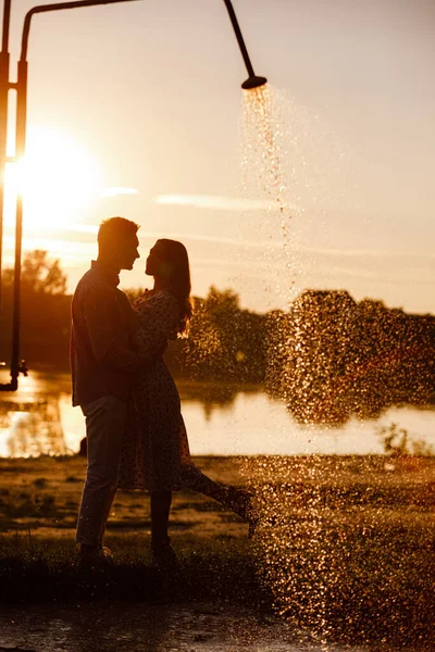 夕阳西下 在湖上拥抱的恋人的轮廓 美丽的年轻夫妇在夕阳西下 在湖畔漫步 沐浴着灿烂的光芒 复制空间 选择性重点 — 图库照片