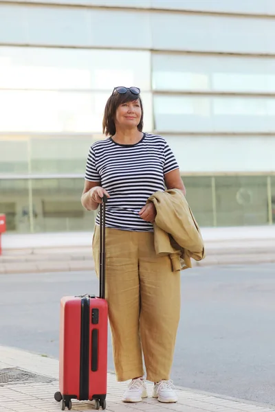 Mature Business Woman Suit Walking Red Suitcase Modern City Background — Φωτογραφία Αρχείου