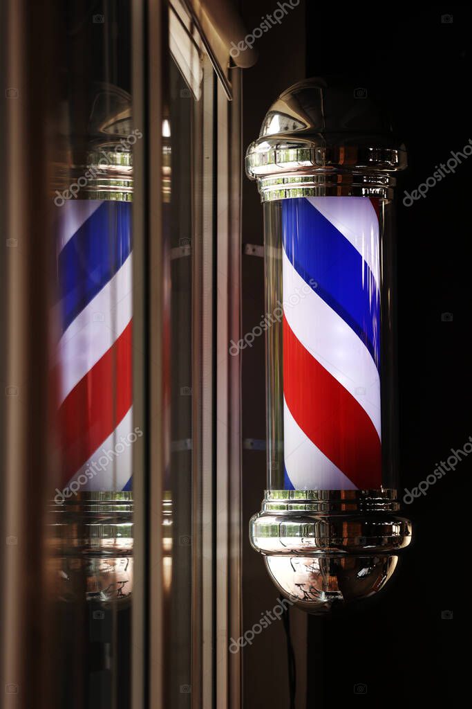 Barber shop vintage pole. copyspace Barbershop. Barber shop pole in red white and blue with lightbulb on top