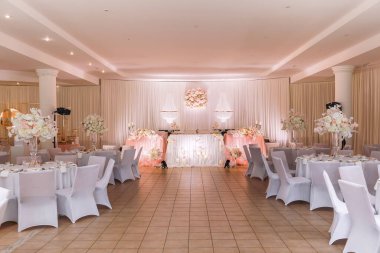 Kristal avizelerle, altın şamdanlarla, mumlarla ve beyaz pembe çiçeklerle süslü bir düğün masası dekorasyonu. şık bir düğün günü..