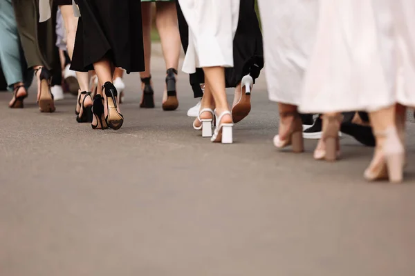 the feet of the group of people are walking outdoors. graduation day. stylish young guys and girls in stylish shoes