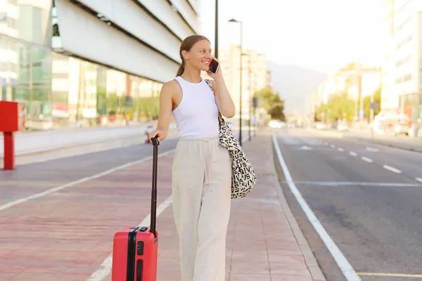 Young Beautiful Woman Red Suitcase Calling Smartphone While Waiting Taxi — Foto Stock