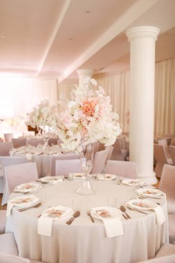 Şenlikli düğün dekorasyonu. Düğün günü yemek masasında cam vazoda duran güzel, beyaz ve pembe çiçekler. Yüksek kalite fotoğraf.