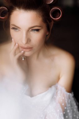 Güzellik konsepti Pembe bukleli parlak makyajlı, gösterişli, genç bir esmer kadının portresi. Stüdyo Çekimi, Kırpılmış. Yüz bakımı. Kozmetoloji, cilt bakımı ve kaplıca.