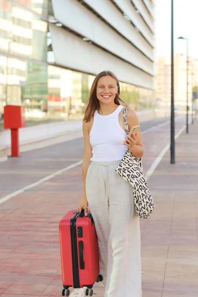 Smiling Woman Uses Cellphone While Walking Red Suitcase Railway Station — Stock Photo, Image