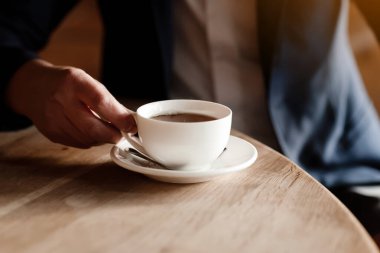 businessman in suit drinking coffee, wealthy successful man holding white cup of coffee or tea sitting by table in cafe, work break of businessman drinking hot drink