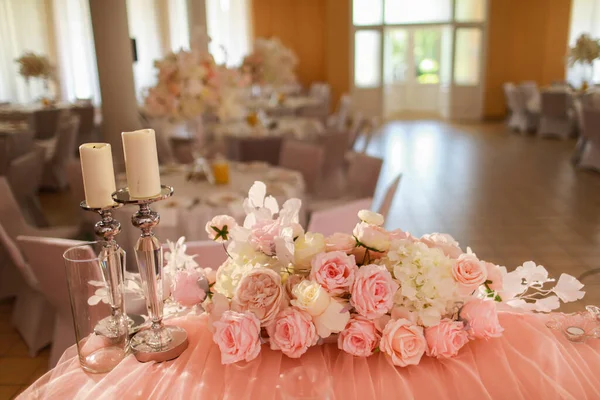クリスタルシャンデリア 黄金の燭台 ろうそく 白いピンクの花とお祝いの結婚式のテーブルの装飾 おしゃれな結婚式の日 — ストック写真
