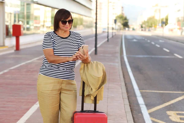 Smiling Senior Woman Sunglasses Red Suitcase Using Smartphone Outdoors Airport — Stock Photo, Image