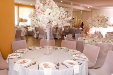 Şenlikli düğün dekorasyonu. Düğün günü yemek masasında cam vazoda duran güzel, beyaz ve pembe çiçekler. Yüksek kalite fotoğraf.